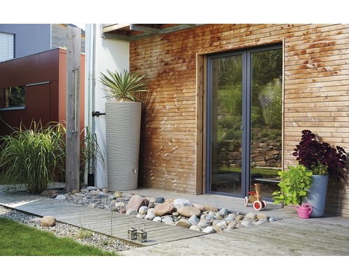 Außenbereich mit Regenwassertonne, Holzwand und Gartendusche.