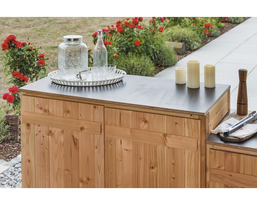 Gartenbar mit Holzverkleidung, Getränkespender, Flasche, Gläsern, Kerzen und Grillzange auf der Oberseite