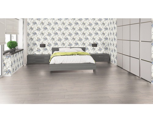 Schlafzimmer mit Bett, Nachttischen, Lampen, Kleiderschrank und floraler Tapete.