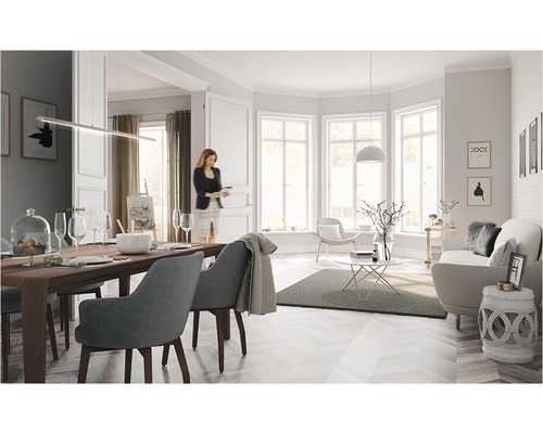 Helles Wohnzimmer mit Esstisch, Stühlen, Sofa und Dekorationen in freundlicher Atmosphäre.