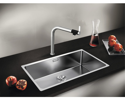 Spüle aus Edelstahl mit Armatur auf einer dunklen Arbeitsplatte