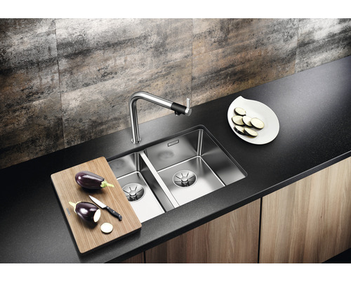Edelstahlspüle mit Armatur und Schneidebrett auf einer Küchentheke