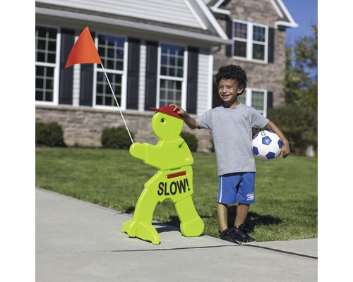 Verkehrsschild mit der Aufschrift Langsam und einem Jungen mit Fußball