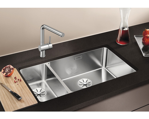 Edelstahlspüle mit zwei Becken und Küchenarmatur auf einer Küchentheke.