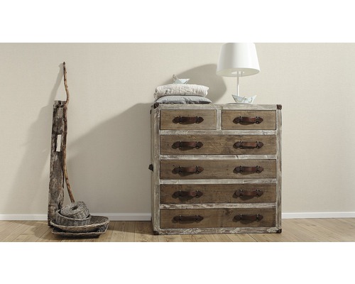 Kommode aus Holz mit mehreren Schubladen und Griffen aus Leder, ergänzt durch eine Lampe und dekorative Elemente.