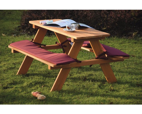 Picknicktisch aus Holz mit Sitzkissen im Garten