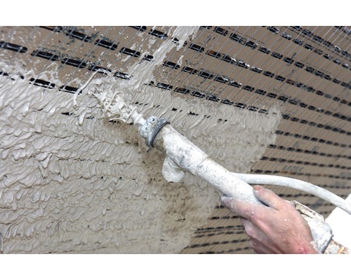 Auftragen von Putz mit einer Putzmaschine auf einer Putzträgerplatte.