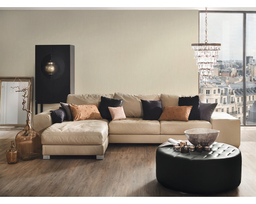 Wohnzimmer mit Ecksofa, Hocker, Schrank und Dekoration