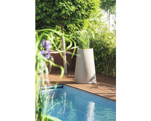 Dekorativer Pflanzkübel aus Kunststoff neben einem Swimmingpool auf einer Holzterrasse im Garten.