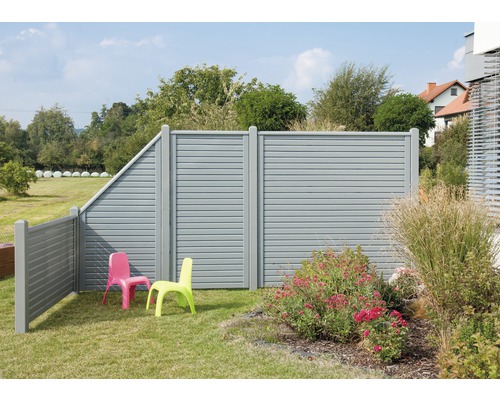 Gartenansicht mit grauem Sichtschutzzaun und zwei Kinderstühlen auf Rasen