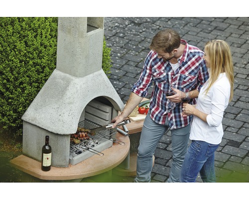 Gemauerter Gartengrill mit Mann und Frau beim Grillen