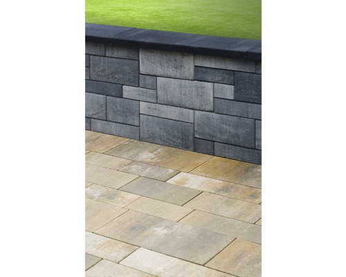 Mauer aus Betonsteinen und Pflastersteinen im Garten