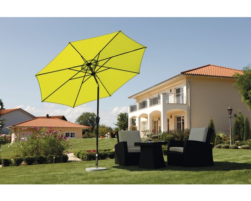 Szene mit gelbem Sonnenschirm und Gartensitzgruppe auf einer Rasenfläche vor einem Haus.