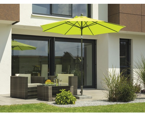 Gartenszene mit Sonnenschirm, Sitzgruppe und Pflastersteinen