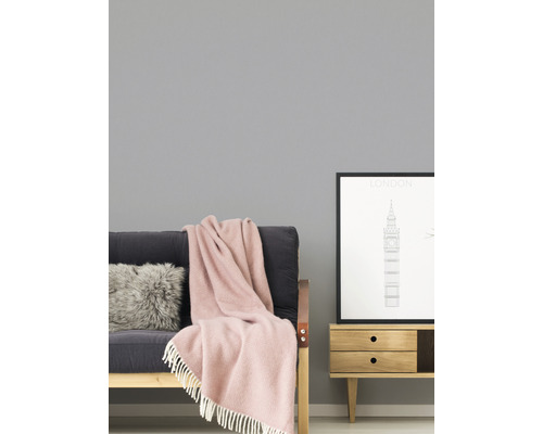 Wohnzimmer mit Sofa, Kissen, Decke und Beistelltisch mit Bilderrahmen