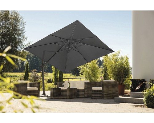 Quadratischer Ampelschirm über einer Rattansitzgruppe im Garten