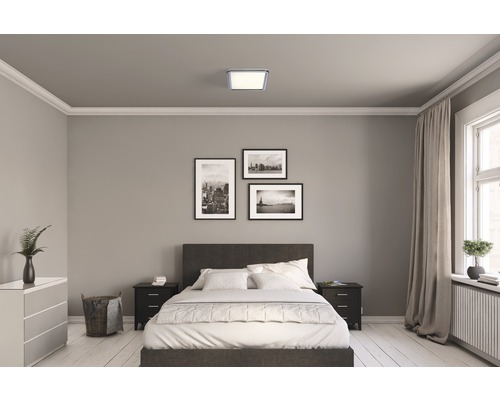 Schlafzimmer mit Bett, Nachttischen und quadratischer Deckenleuchte