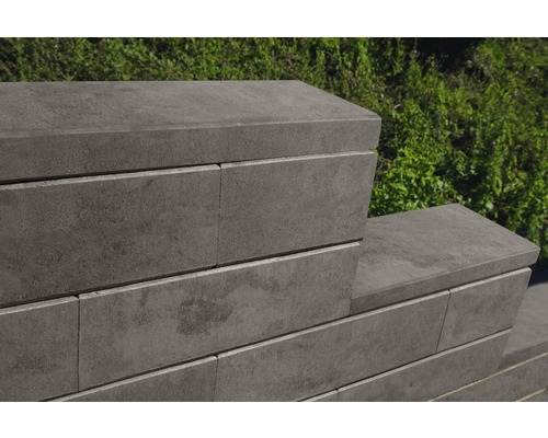 Detailansicht einer Mauer aus grauen Betonsteinen im Garten