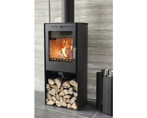 Schwarzer Kaminofen mit Holz und Kaminbesteck