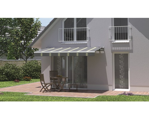 Hausfassade mit Markise über Terrassentür und Sitzgruppe auf Terrasse