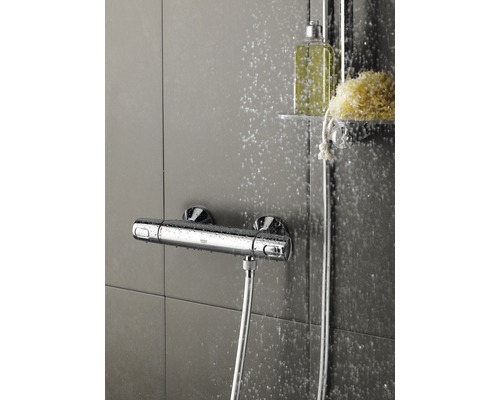 Aufputz-Thermostatbatterie mit Brauseschlauch in einer Dusche.