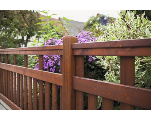 Holzzaun mit Blumen im Garten