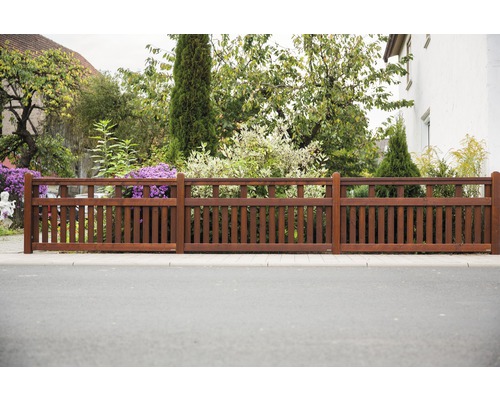 Holzzaun vor einem Garten mit Pflanzen