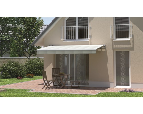 Hausfassade mit Markise über Terrasse mit Tisch und Stühlen