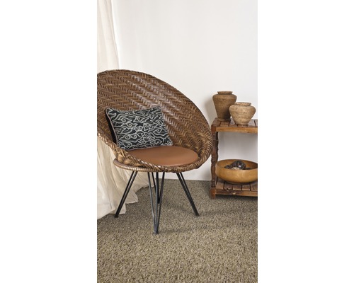 Dekoratives Zimmer mit Korbsessel, Kissen, Regal und Wohnaccessoires