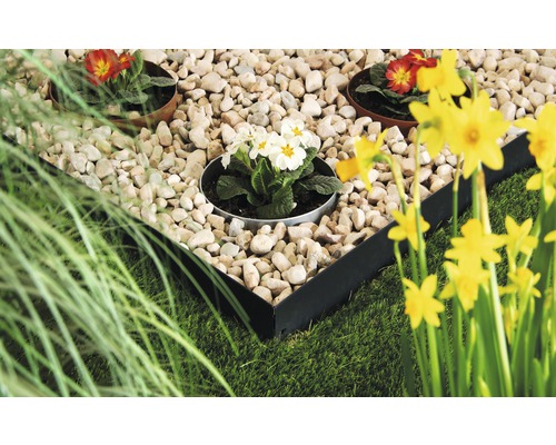 Gartenszene mit Rasen, Steinen, Blumen und einer Metalleinfassung für Beete