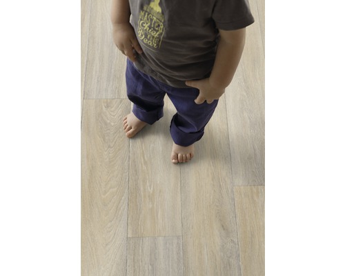 Kind steht auf hellem Laminatboden in Holzoptik