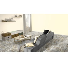 Wohnzimmer mit grauer Couch, Kommode und gemustertem Boden