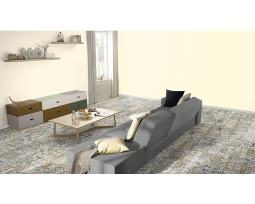 Wohnzimmer mit grauer Couch, Kommode und gemustertem Boden