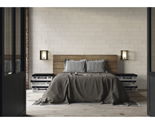 Schlafzimmer mit Holzbett, Nachttischen im Kofferdesign und Wandfliesen in Ziegeloptik