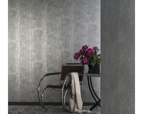 Wohnraum mit grauer Wandtapete in Steinoptik, Sessel und Beistelltisch mit Blumenstrauß