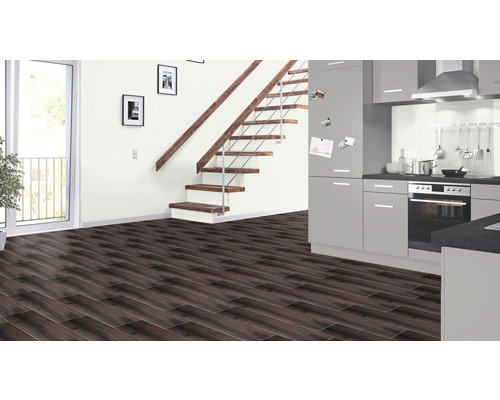 Modernes Interieur mit dunklem Laminatboden, Treppe mit Holzstufen und grauer Küchenzeile.