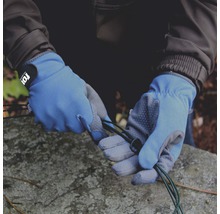 Hände mit Arbeitshandschuhen halten ein grünes Kabel