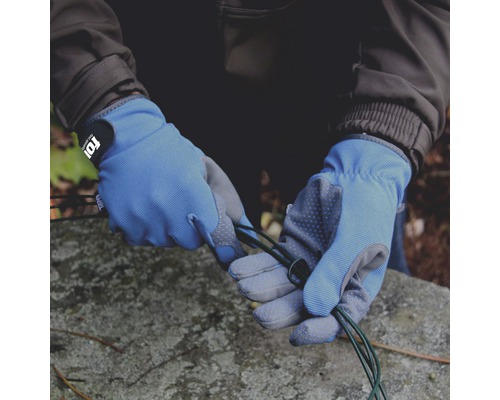 Hände mit Arbeitshandschuhen halten ein grünes Kabel