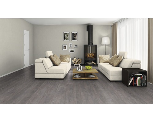 Wohnzimmer mit grauen Bodenbelag, Kamin und weißen Sofas.