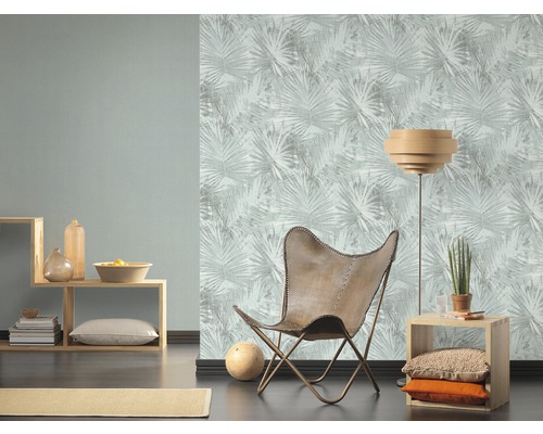 Wohnzimmer mit Sessel, Stehlampe und Tapete mit Blättermuster