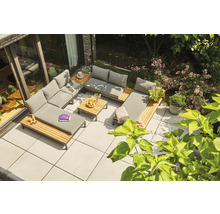 Gartenlounge-Set auf einer Terrasse mit Holzdetails und grauen Polstern, umgeben von üppigem Grün