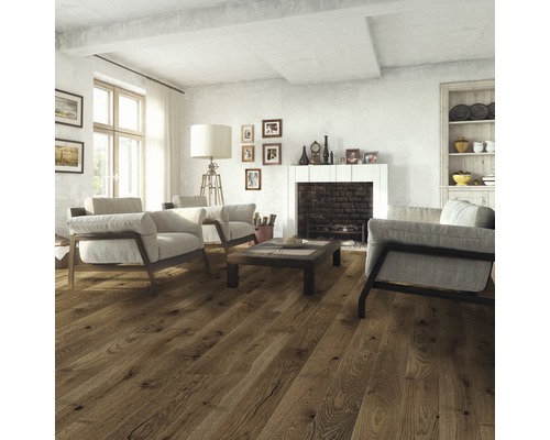 Wohnzimmer mit Holzboden, Sesseln und Kamin.