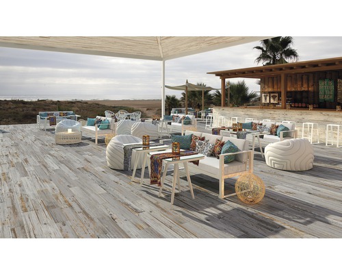 Außenbereich mit Holzboden, Sitzmöbeln und Bar am Strand