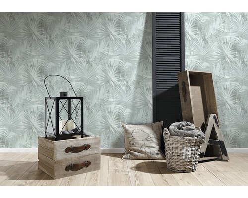 Wohnraum mit gemusterter Tapete, Laterne, Holzkisten, Kissen und Wäschekorb für eine gemütliche Atmosphäre