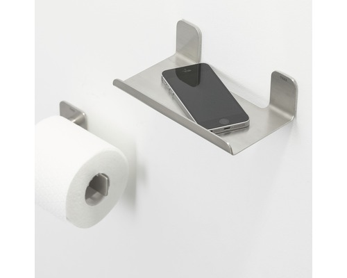 Toilette mit Toilettenpapierhalter und Ablage aus Metall mit Mobiltelefon