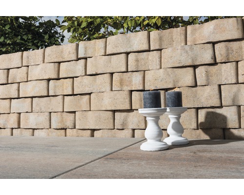 Gartenmauer aus Betonsteinen mit zwei Kerzenleuchtern