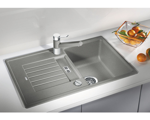 Spüle aus Stein mit Abtropffläche und Wasserhahn