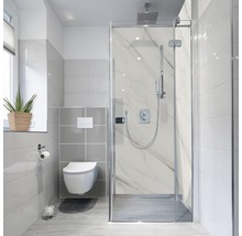 Helles Badezimmer mit Dusche, Toilette und Fenster.