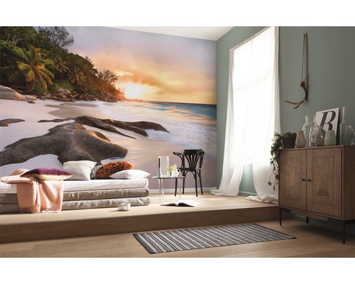 Wohnraum mit Fototapete einer tropischen Strandszene bei Sonnenuntergang