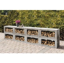 Holzlager aus Betonsteinen mit Holzscheiten und einer Pflanze im Topf